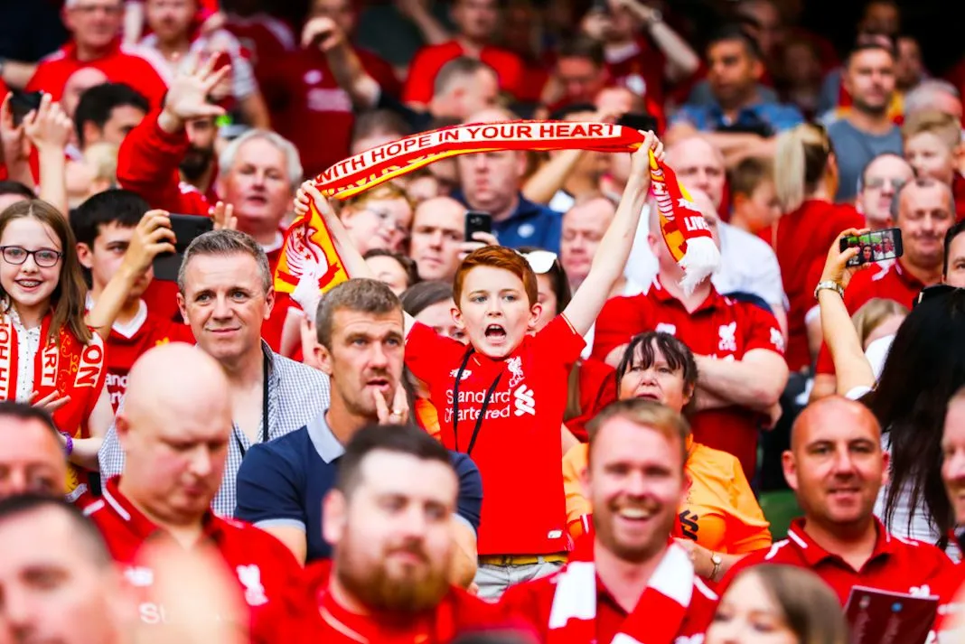 Les fans de Liverpool rentrent à la maison avec deux réfugiés dans leur bus